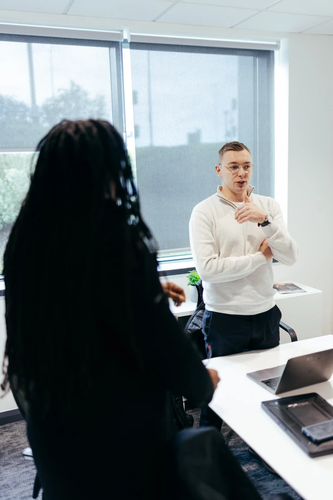 Brad Matthews in conversation with a colleague in the office